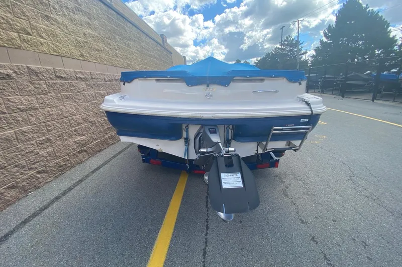 Slide: The Image of 1998 Glastron/Carlson GS225 boat, rear view, parked on a street with blue cover. - 7
