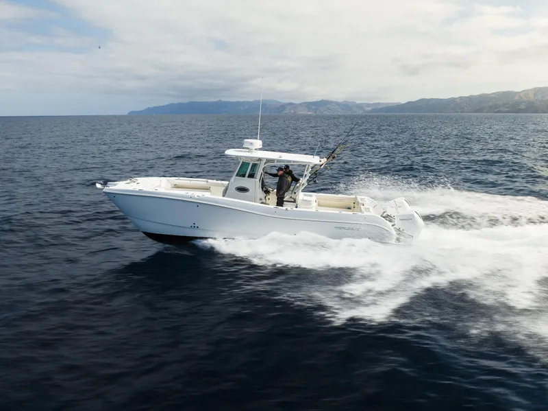 Slide: The Image of 2026 World Cat 325CC cruising on open ocean with scenic coastline in background. - 0