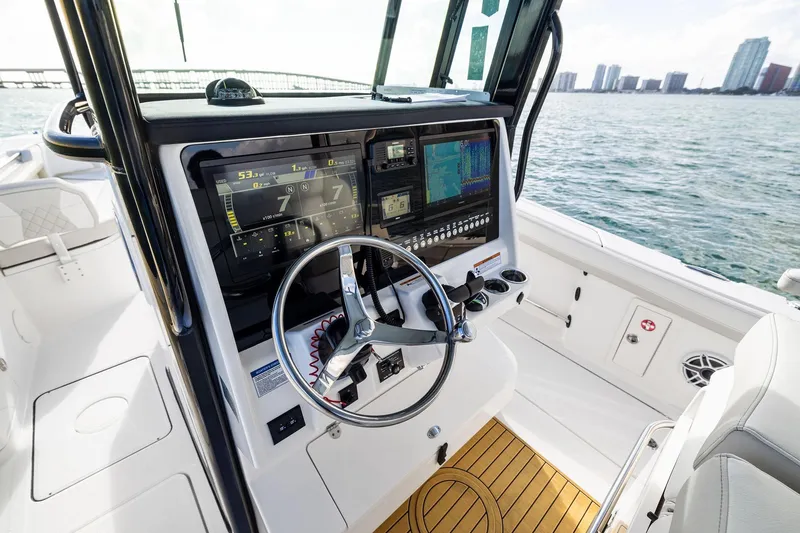 Slide: The Image of 2026 World Cat 325CC boat cockpit with advanced navigation system and steering wheel. - 22