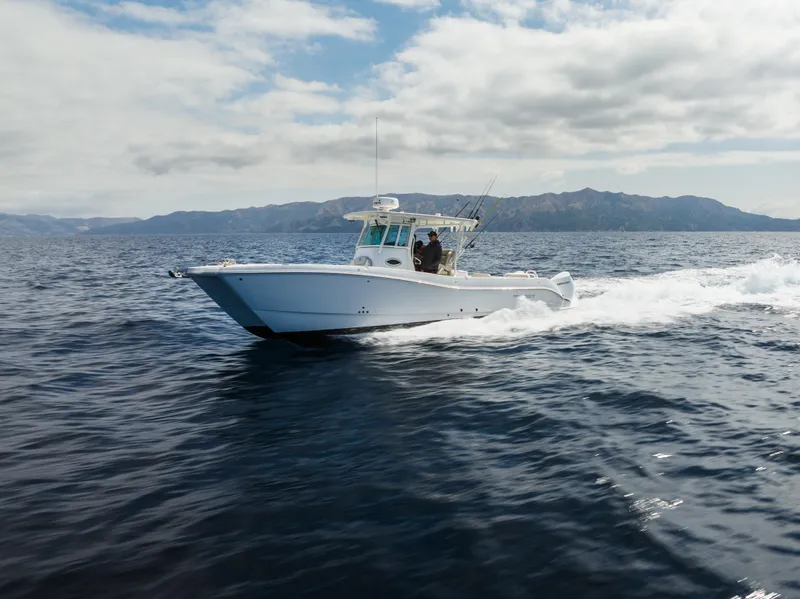 Slide: The Image of 2026 World Cat 325CC cruising on open water under a partly cloudy sky. - 4