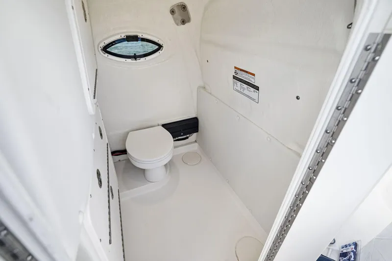 Slide: The Image of 2026 World Cat 325CC boat interior with compact marine toilet and porthole window. - 9