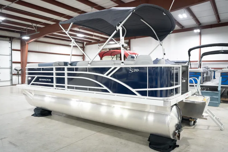 Slide: The Image of 2026 Bennington 20 SFC pontoon boat in showroom, featuring canopy and modern design. - 10