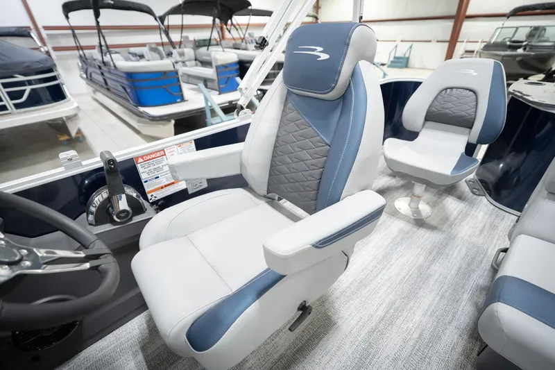 Slide: The Image of 2026 Bennington 20 SFC boat interior with blue and gray seating in showroom. - 30