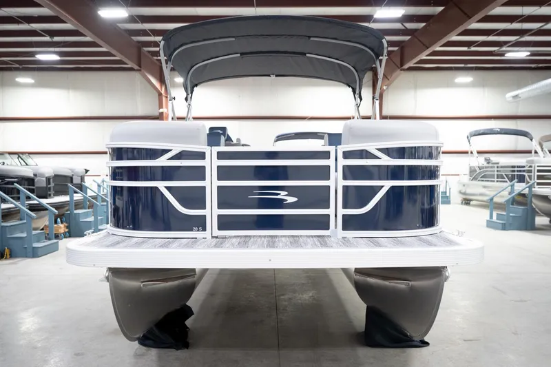 Slide: The Image of 2026 Bennington 20 SFC pontoon boat in indoor showroom, featuring sleek design and canopy. - 5