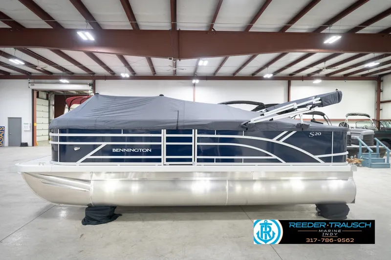 Slide: The Image of 2026 Bennington 20 SFC pontoon boat in indoor showroom, covered and ready for display. - 62