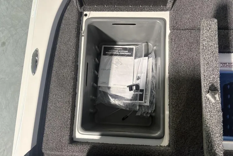 Slide: The Image of Open storage compartment in 2026 Nitro Z18 Pro boat with manuals and accessories. - 24