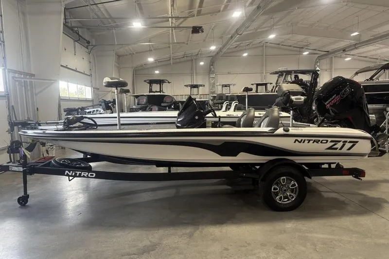 The Image of 2026 Nitro Z17 boat in showroom, side view, on trailer, under bright lighting. - 2