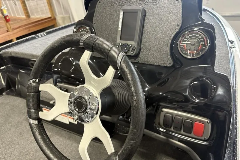 Slide: The Image of Steering wheel and dashboard of a 2026 Nitro Z17 boat, featuring gauges and controls. - 23