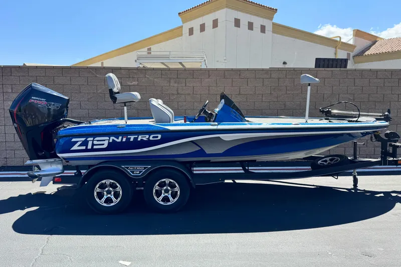 The Image of 2022 Nitro Z19 boat with Mercury Pro XS engine on trailer, parked outdoors. - 0
