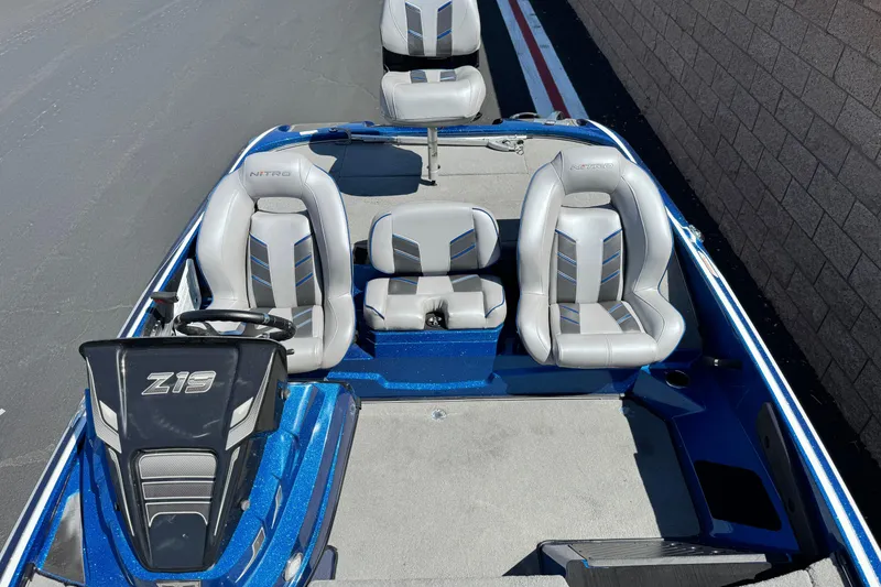 Slide: The Image of 2022 Nitro Z19 boat interior with gray seats and steering console. - 12