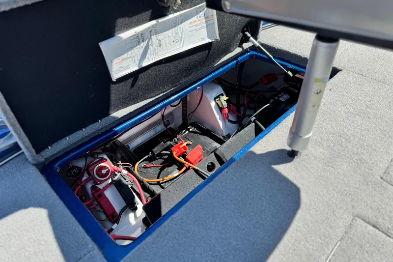 Slide: The Image of Open storage compartment in 2022 Nitro Z19 boat, showing battery and wiring. - 16