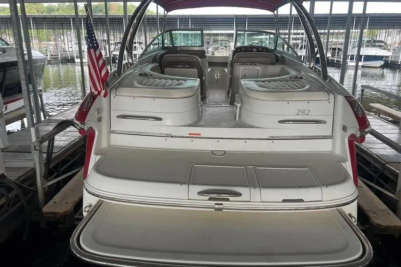 Slide: The Image of 2003 Cobalt 282 boat docked, rear view with American flag, spacious seating. - 12