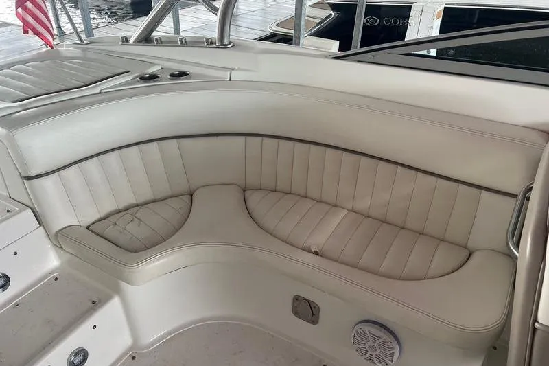 Slide: The Image of 2003 Cobalt 282 boat interior with white leather seating and cup holders. - 2