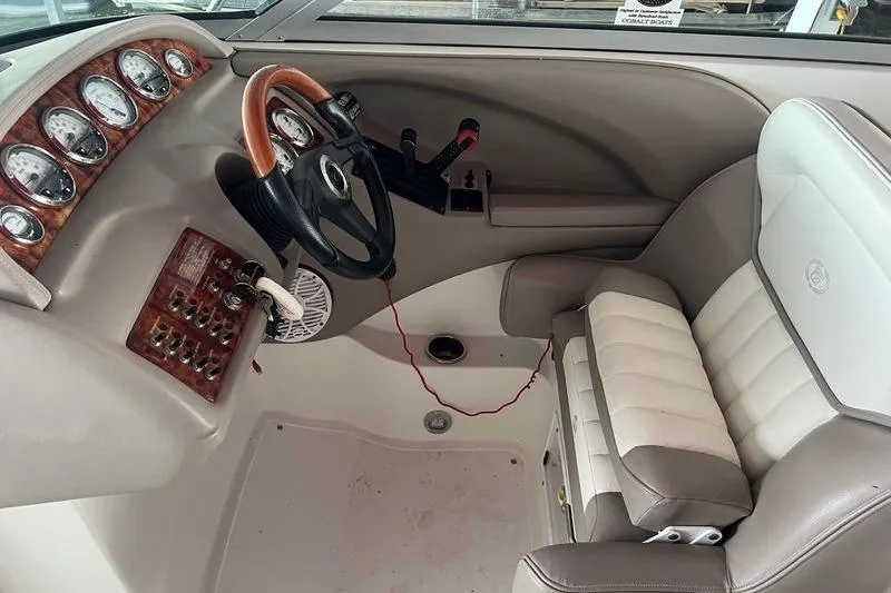 Slide: The Image of Interior of a 2003 Cobalt 282 boat with steering wheel and control panel. - 8