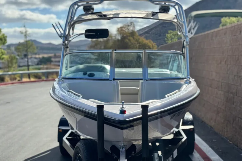 Slide: The Image of 2006 Correct Craft Super Air Nautique 210 Sport boat on trailer, scenic background. - 2