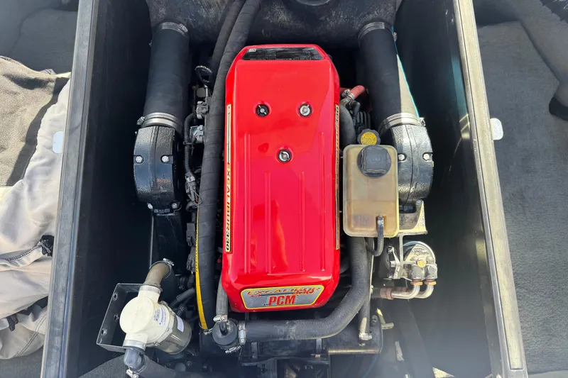 Slide: The Image of 2006 Correct Craft Super Air Nautique 210 Sport engine with red cover and components. - 21