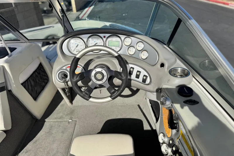 Slide: The Image of 2006 Correct Craft Super Air Nautique 210 Sport boat dashboard with steering wheel and gauges. - 26