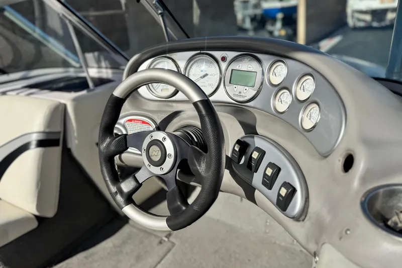 Slide: The Image of 2006 Correct Craft Super Air Nautique 210 Sport dashboard with steering wheel and gauges. - 27