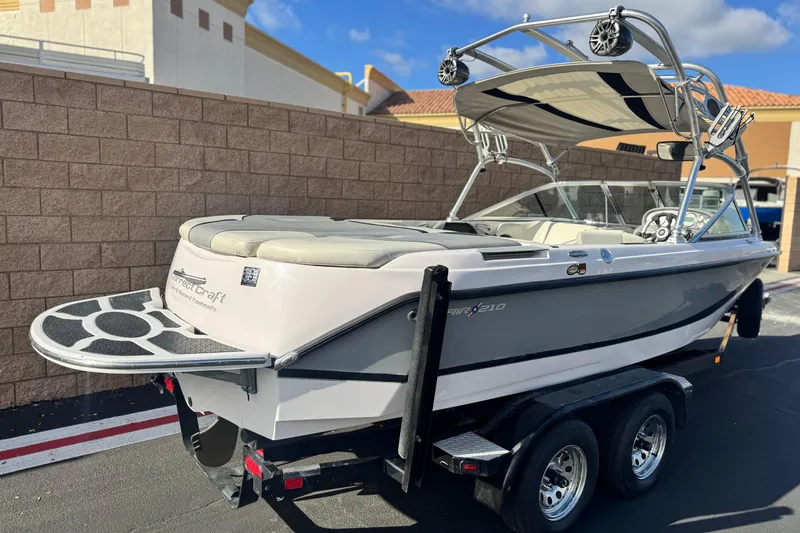 Slide: The Image of 2006 Correct Craft Super Air Nautique 210 Sport boat on trailer, parked outdoors. - 5