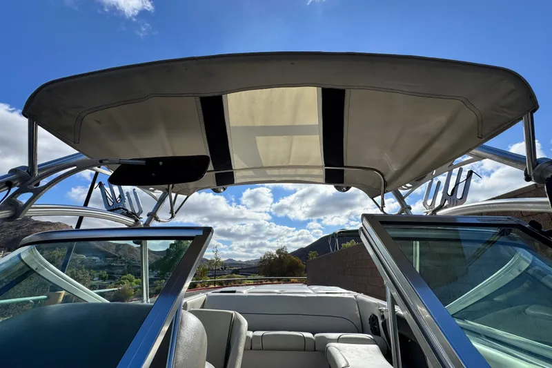 Slide: The Image of 2006 Correct Craft Super Air Nautique 210 Sport boat interior with canopy and clear sky. - 9
