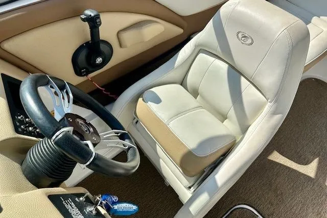 Slide: The Image of 2015 Cobalt 220S boat interior with steering wheel and beige seating. - 15