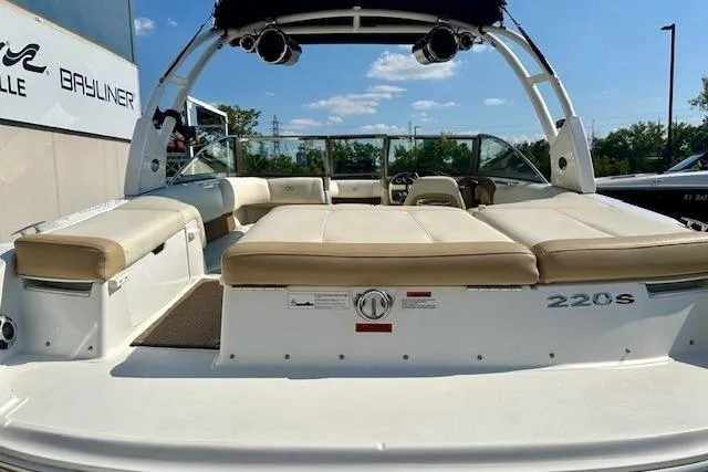 Slide: The Image of 2015 Cobalt 220S boat with beige seating and sleek design, docked outdoors. - 7