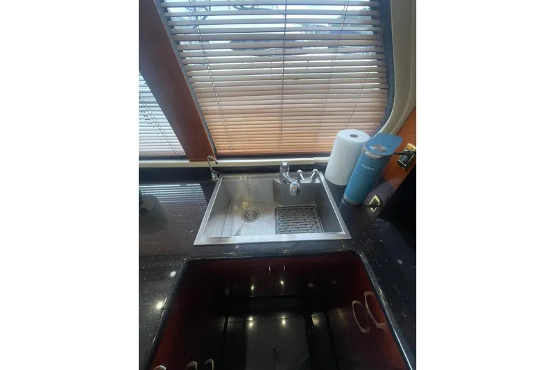 Slide: The Image of Wooden cabinetry with open drawers in 2004 Carver 570 Voyager Pilothouse kitchen. - 15