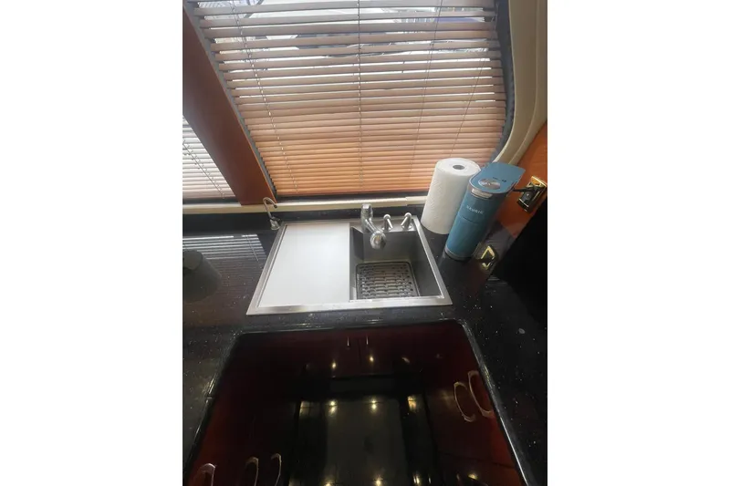 Slide: The Image of Kitchen sink area in 2004 Carver 570 Voyager Pilothouse with blinds and countertop items. - 16