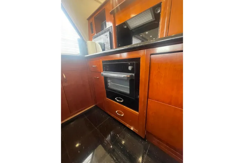 Slide: The Image of 2004 Carver 570 Voyager Pilothouse kitchen with microwave, toaster, and Keurig coffee maker. - 19