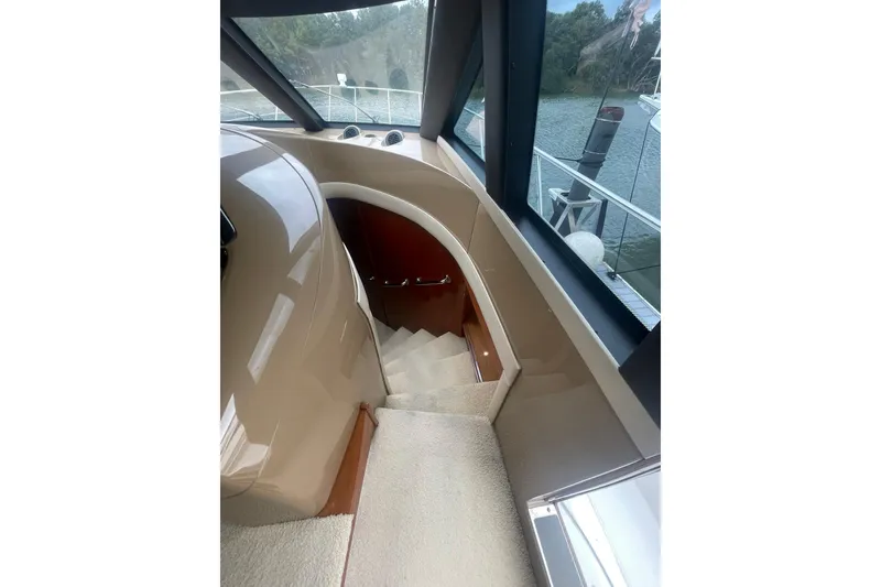Slide: The Image of Interior view of 2004 Carver 570 Voyager Pilothouse, featuring helm and elegant wood cabinetry. - 21