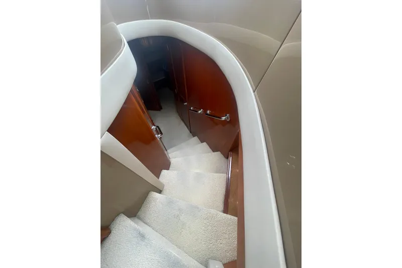Slide: The Image of Interior staircase of 2004 Carver 570 Voyager Pilothouse yacht, featuring elegant design and carpeting. - 22