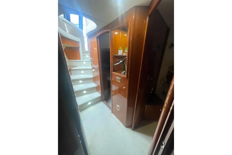 Slide: The Image of Staircase inside 2004 Carver 570 Voyager Pilothouse yacht with wooden paneling and carpeted steps. - 23