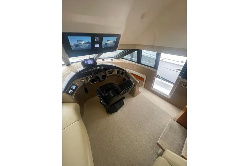 Slide: The Image of Interior view of 2004 Carver 570 Voyager Pilothouse, featuring helm and large windows. - 49