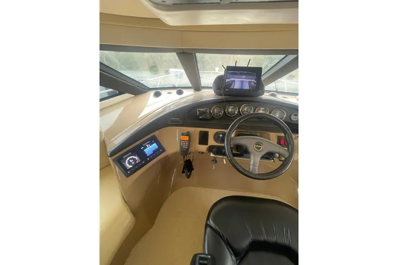 Slide: The Image of 2004 Carver 570 Voyager Pilothouse helm with control panel and communication devices. - 57