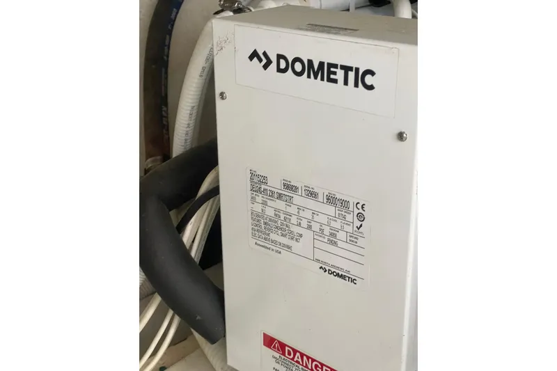 Slide: The Image of Dometic unit in 2004 Carver 570 Voyager Pilothouse engine room with cables and warning label. - 66