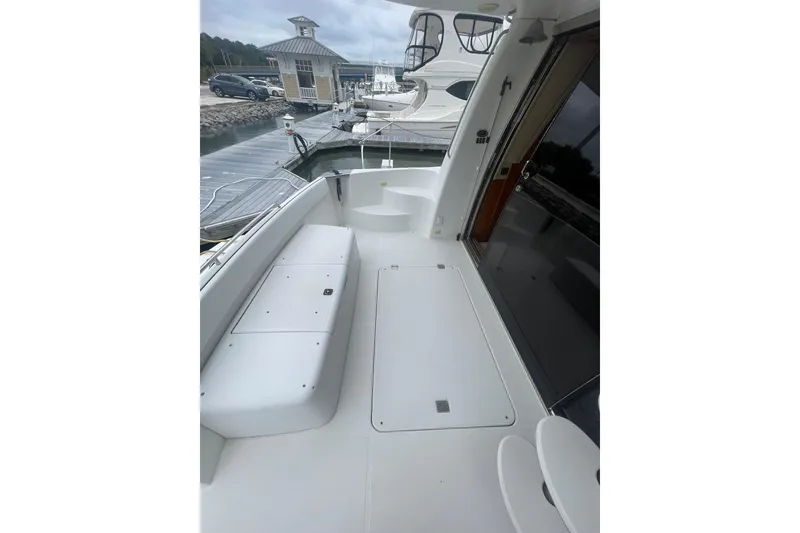 Slide: The Image of 2004 Carver 570 Voyager Pilothouse yacht deck with seating and dock view. - 80