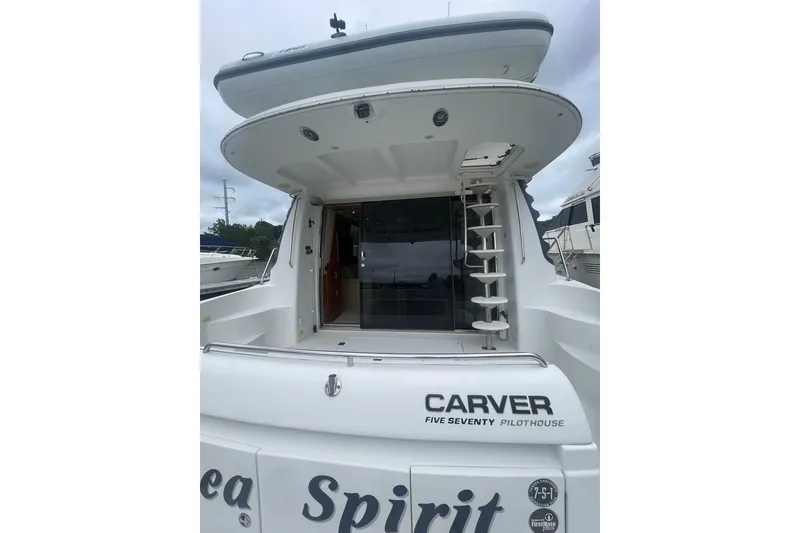 Slide: The Image of 2004 Carver 570 Voyager Pilothouse yacht deck with seating, docked at marina. - 81