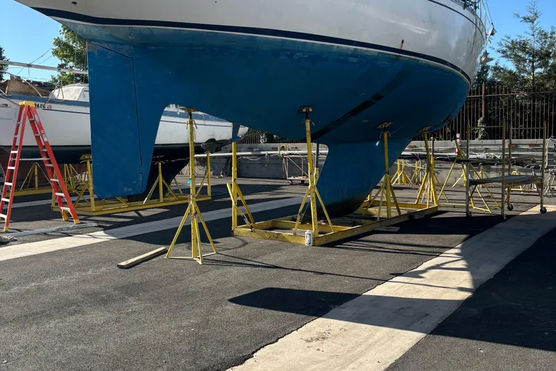 Slide: The Image of Nautor Swan 47 sailboat under maintenance, showcasing propeller and hull, 1980 model. - 10