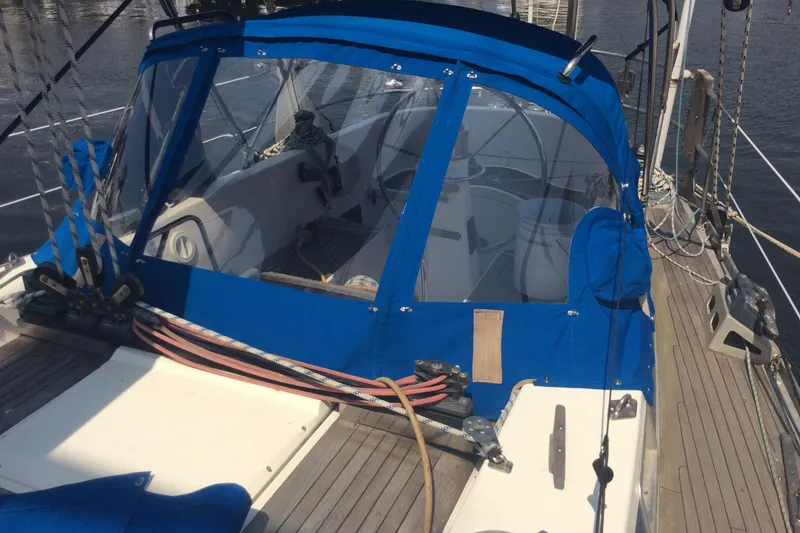 Slide: The Image of Cockpit of 1980 Nautor Swan 47 sailboat with blue cushioned seating and metal steering wheel. - 14
