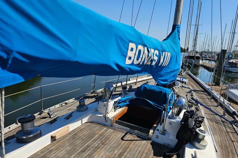 Slide: The Image of Deck of 1980 Nautor Swan 47 sailboat docked at marina, showcasing wooden finish and rigging. - 2