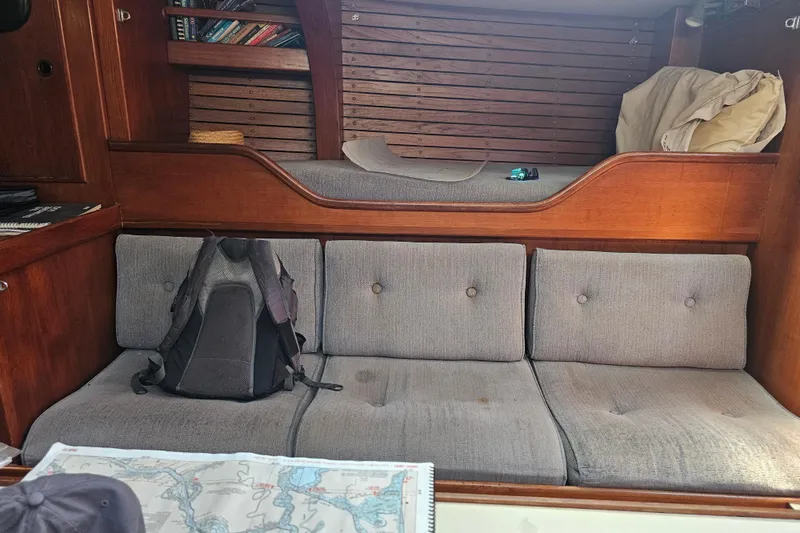 Slide: The Image of Interior of 1980 Nautor Swan 47 sailboat, featuring cozy seating and wooden finishes. - 21