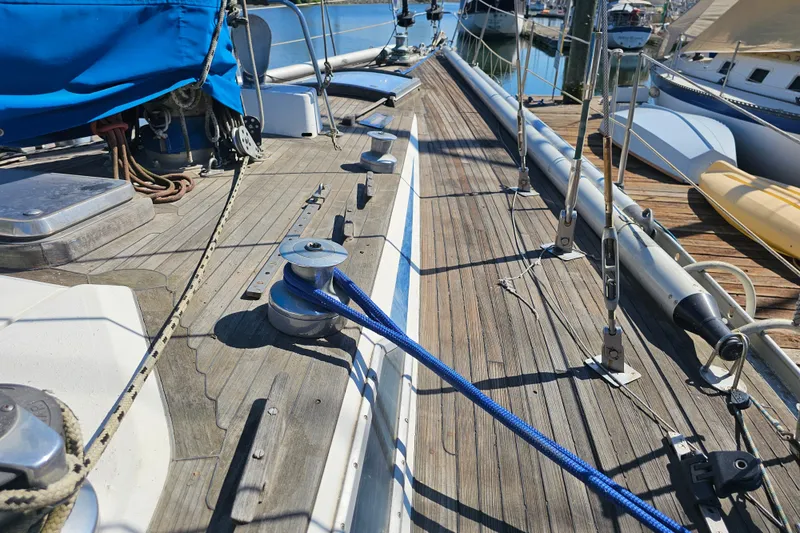 Slide: The Image of Deck of 1980 Nautor Swan 47 sailboat with wooden finish and blue covers. - 3