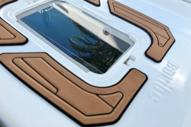Slide: The Image of Close-up of Caribe MPV 10 boat hatch with palm tree reflection, 2025 model. - 16