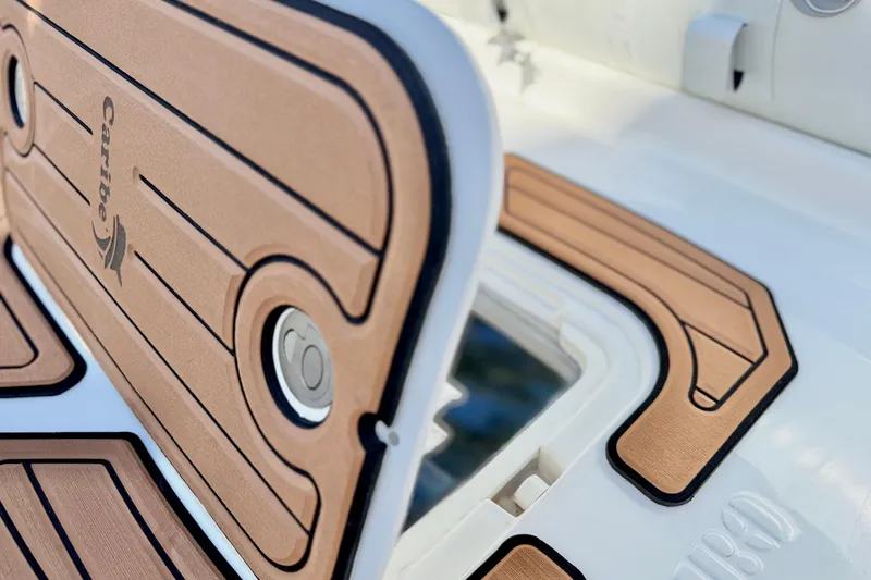 Slide: The Image of 2025 Caribe MPV 10 boat deck with tan and black detailing. - 21