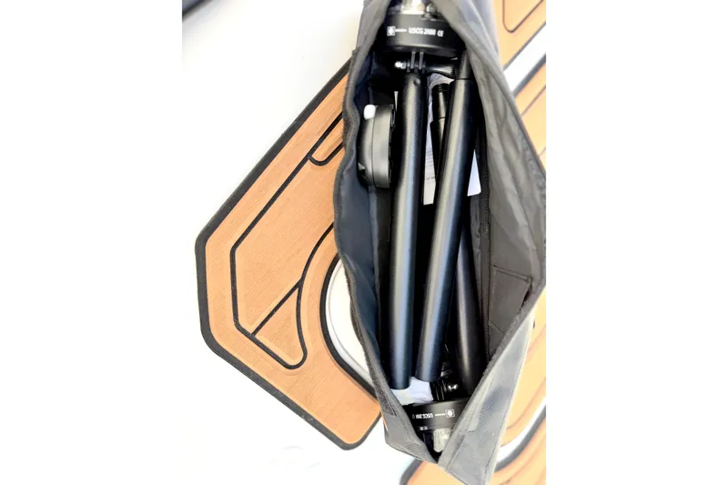 Slide: The Image of Bag containing folded tripod on wooden surface, related to Caribe MPV 10, 2025 model. - 23