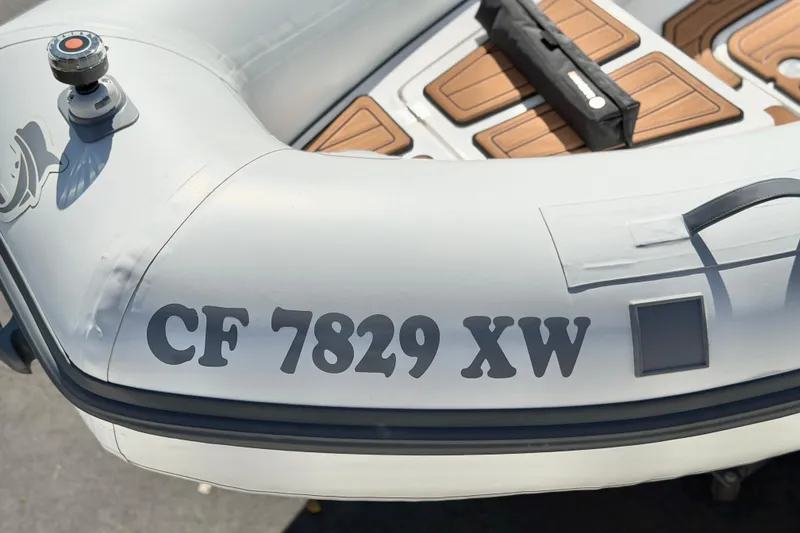 Slide: The Image of Inflatable boat with registration "CF 7829 XW," featuring brown seating, Caribe MPV 10, 2025 model. - 27