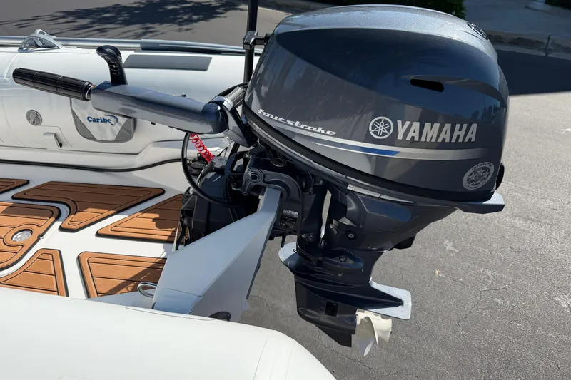 Slide: The Image of 2025 Caribe MPV 10 boat with Yamaha four-stroke outboard motor, featuring teak-style flooring. - 29