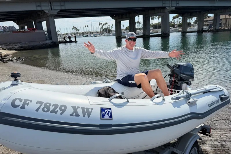 Slide: The Image of Man enjoying a ride on a Caribe MPV 10 inflatable boat near a bridge. - 40