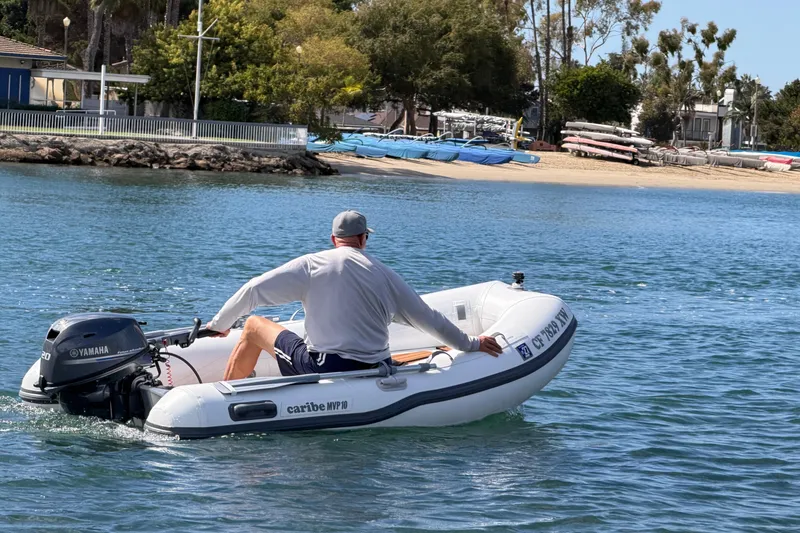 Slide: The Image of Man operating 2025 Caribe MPV 10 inflatable boat on calm water. - 46