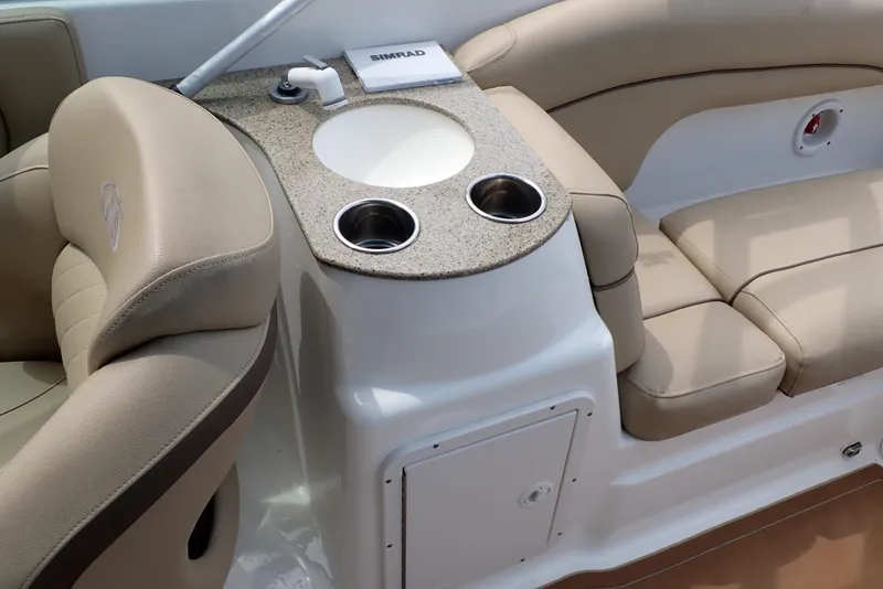Slide: The Image of 2019 NauticStar 243DC Sport Deck interior with beige seating and built-in cup holders. - 10